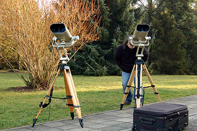 Dvojice binokulárních dalekohledů na stativech.